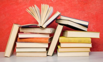 pile-of-books-against-red-wall